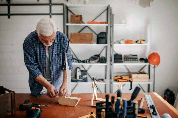 istock Senior man making boat from wooden piece 1146225863