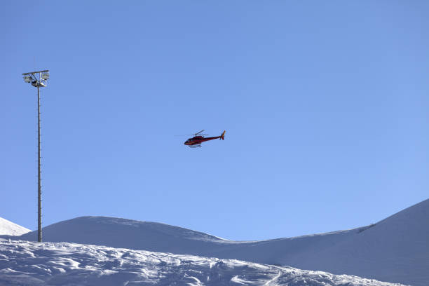 istock Helicopter in blue clear sky and snowy ski slope 1146229437