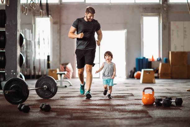 Father having good time with his son in the gym after workout