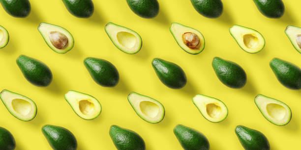 avocado-muster auf gelbem hintergrund. pop-art-design, kreatives sommer-food-konzept. green avocados, minimaler flachlay-stil. top view - supermarkt fotos stock-fotos und bilder