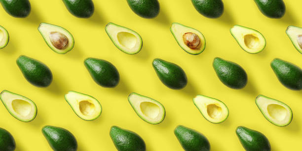 istock Avocado pattern on yellow background. Pop art design, creative summer food concept. Green avocadoes, minimal flat lay style. Top view 1146236141