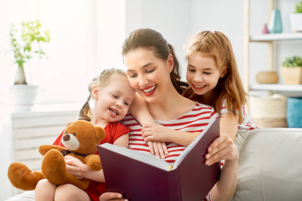 istock mother reading a book to daughters 1146237442