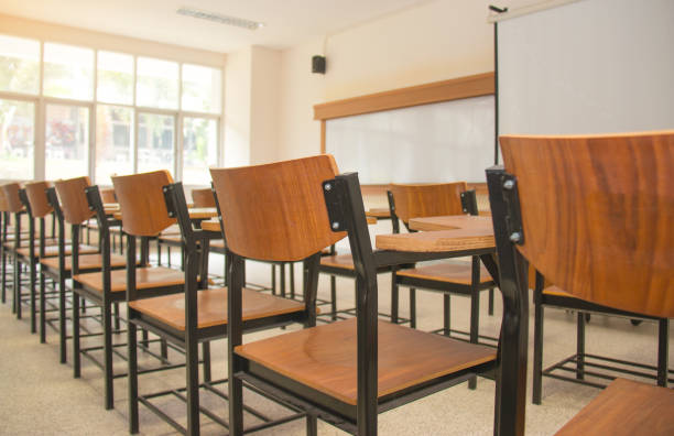 istock University classroom with desks, blackboard and screen projector in Thailand university 1146240285
