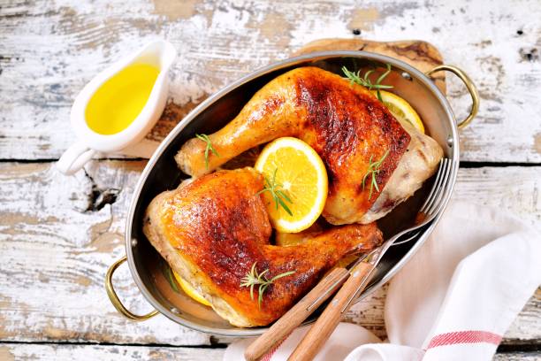 istock Chicken legs baked with orange slice and rosemary. 1146240542
