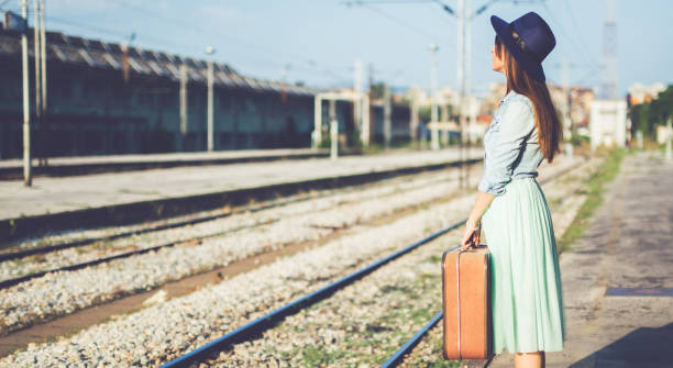 istock Woman standing and waits train on railway platform 1146240576