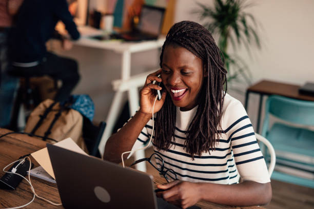 istock African woman working in a modern co-working space and using phone charging station 1146241654