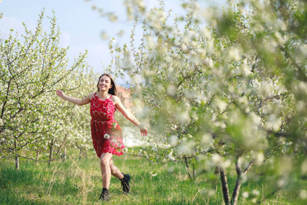 istock Young woman among blooming trees 1146241837