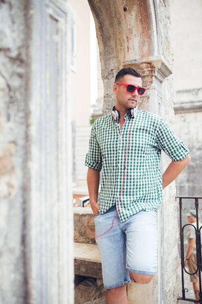 istock Man with headsets enjoying to walk in old town Budva Montenegro. 1146242513