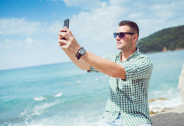 istock Young man relaxing on coast of Budva Montenegro and make selfie. 1146242567