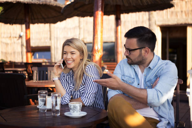 istock A handsome young man gets angry because his girlfriend talks to the phone with another man 1146242803