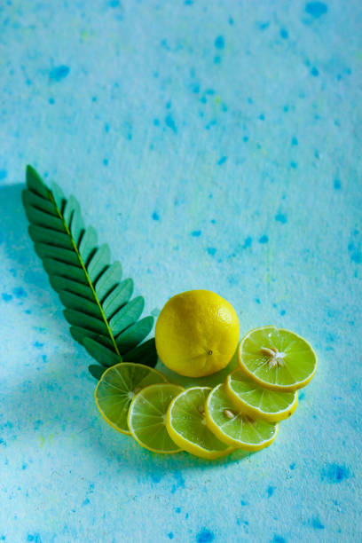 citron jaune et vert frais sur le fond bleu - healthy eating nature studio shot vertical photos et images de collection
