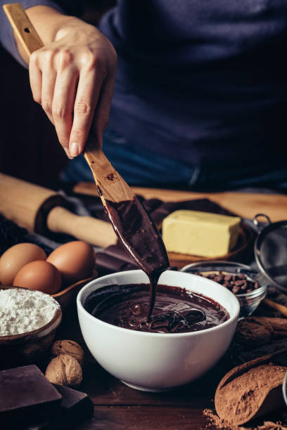 istock Woman hands making chocolate mousse and cookies on a wooden table in a rustic kitchen 1146245720
