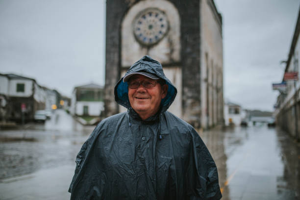 ritratto di uomo anziano felice che indossa un impermeabile in galizia, spagna. - portomarin foto e immagini stock