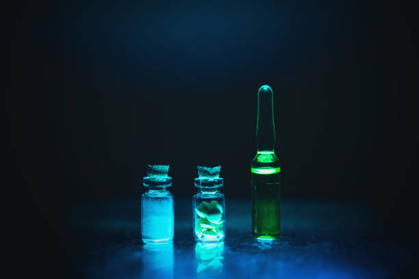 Unmarked glass chemical bottles filled with yellow chemical solution such as illegal sports performance enhancing anabolic steroids. Unmarked glass chemical bottles filled with yellow chemical solution such as illegal sports performance enhancing anabolic steroids. artistic dark filter. low key photo erythropoietin stock pictures, royalty-free photos & images