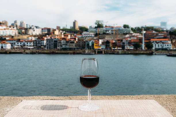 vaso de vino tinto de oporto con vistas a vila nova de gaia, oporto, portugal - portugal port wine porto the douro fotografías e imágenes de stock