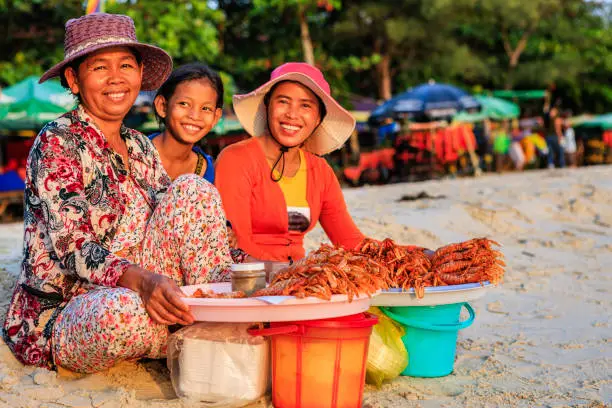 Happy Cambodian women selling fresh lobsters on the beach, Sihanoukville, Cambodia