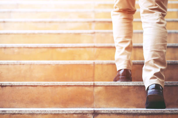 fermer les jambes chaussures de jeune homme d’affaires une personne marchant marcher en haut des escaliers dans la ville moderne, monter, le succès, grandir. avec filtre tons rétro vintage effet chaud. escalier - staircase old fashioned antique architectural feature photos et images de collection