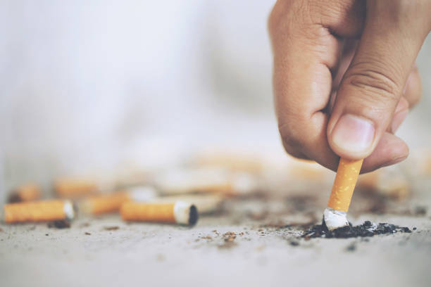 istock Hand putting out a cigarette,cigarette butt on Concrete floor, bare cement. 1146255033