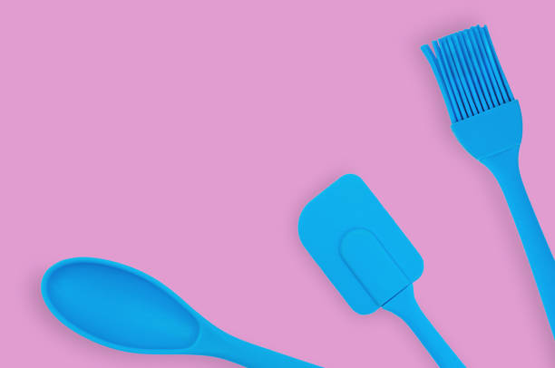 istock Blue rubber or silicone brush, spoon and spatula with plastic handles for confectionery on pink table in kitchen. Flat lay. Copy space for your text 1146255364