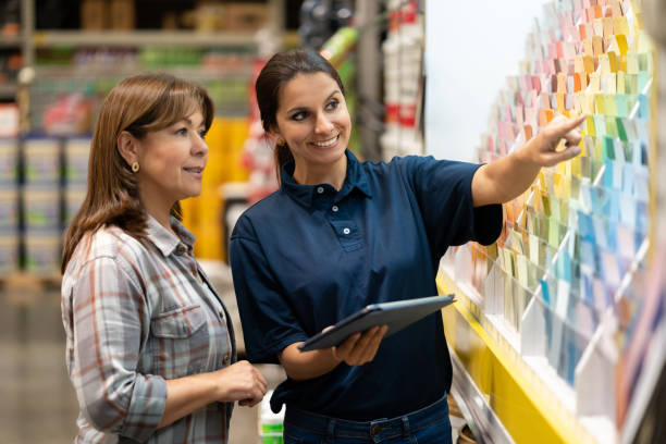 woman at a home improvement store choosing paint colors - home addition home improvement paint decorating imagens e fotografias de stock