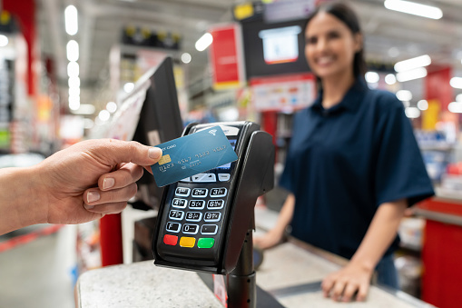 Close-up on a customer making a smart payment at the hardware store - business concepts. **DESIGN ON CARD WAS MADE FROM SCRATCH BY US**