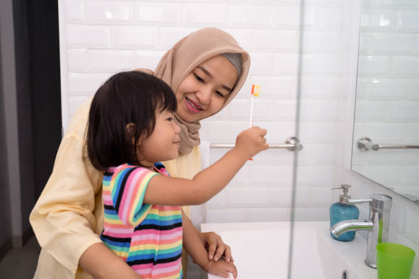 istock mother and her daughter brushing teeth 1146259330