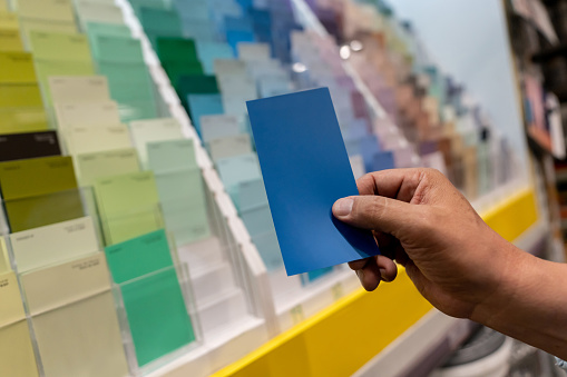 close-up on a customer holding a color sample at a hardware store - remodeling an painting concepts