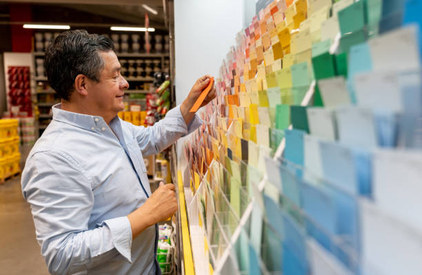 istock Man at hardware store choosing a color for his house project 1146259335