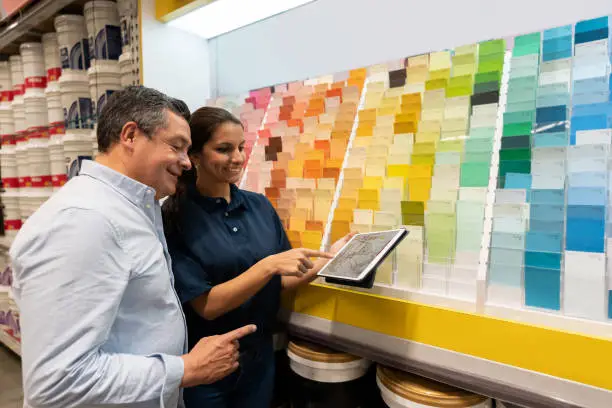 Photo of Man at hardware store buying paint and talking to the saleswoman