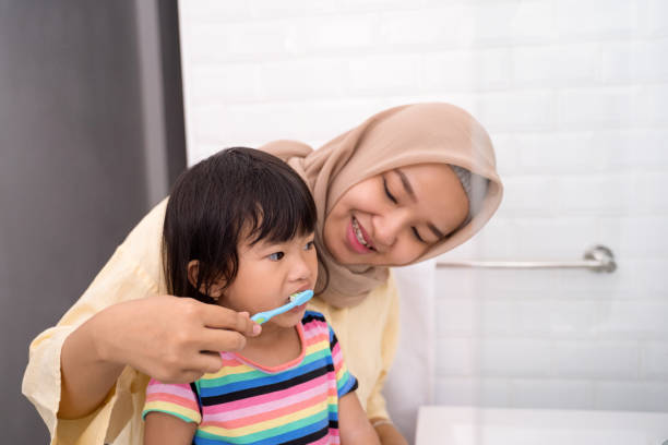 istock mom brush her kid's teeth 1146259429