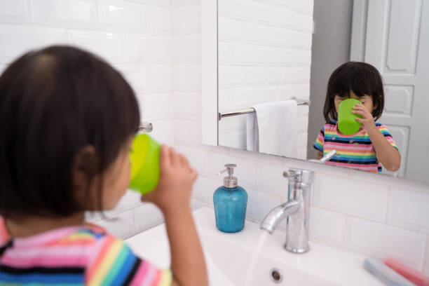 子供は口を洗うかうがいをする - うがい 子ども ストックフォトと画像