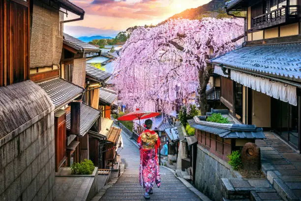 Photo of Woman wearing japanese traditional kimono walking at Historic Higashiyama district in spring, Kyoto in Japan.