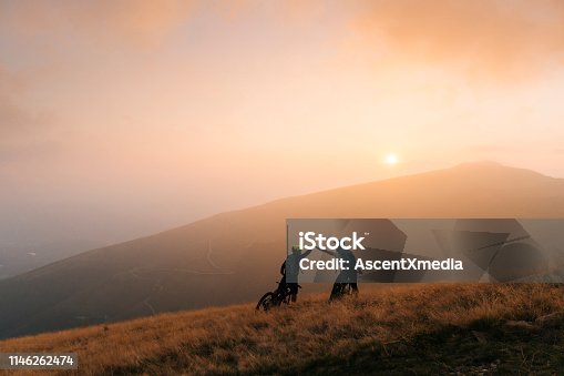 istock Mountain bikers give high-five at sunset 1146262474
