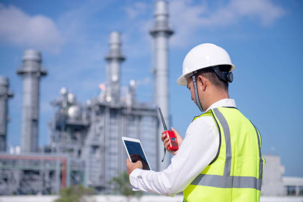 engineers use radio communication & smart tablet with factory worker. they work at the power plant - building contractor engineer digital tablet construction imagens e fotografias de stock