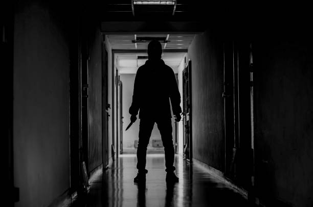 murder, kill and people concept - Criminal or murderer wearing a mask in silhouette holding knife inside a condo at crime scene murder, kill and people concept - Criminal or murderer wearing a mask in silhouette holding knife inside a condo at crime scene knife weapon photos stock pictures, royalty-free photos & images
