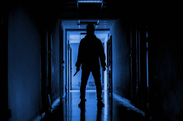 istock murder, kill and people concept - Criminal or murderer wearing a mask in silhouette holding knife inside a condo at crime scene 1146265234