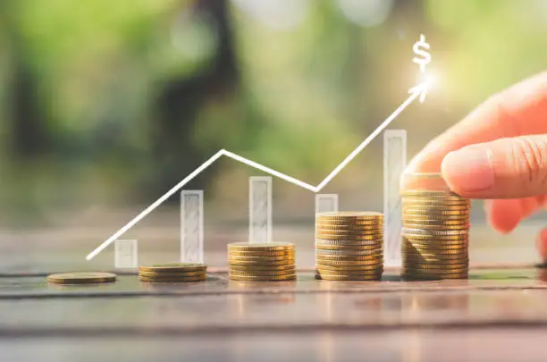 Photo of loan investment residential building house, real estate, property, mortgage concept. hand put coin stacking on wood table in green park background. startup graph growth up wealth.ESG.financial saving.