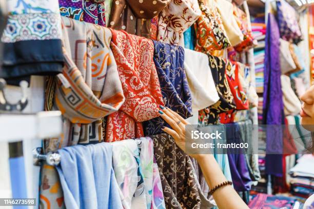 Young Woman Shopping For A New Scarf And Choosing Colorful Fabric In Bazar Stock Photo - Download Image Now