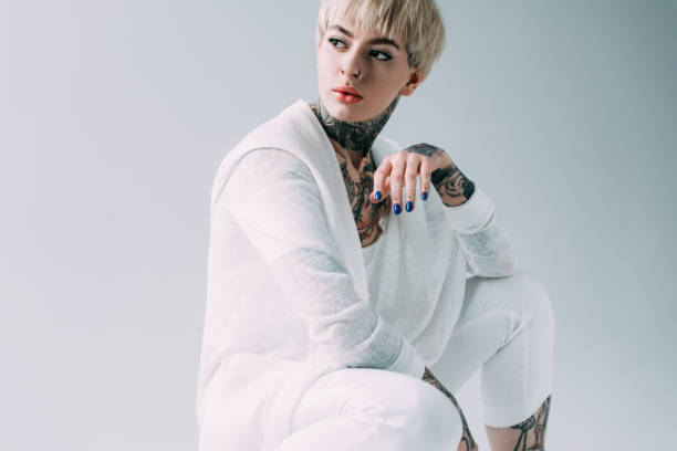 istock attractive woman with tattoos sitting isolated on grey 1146274677