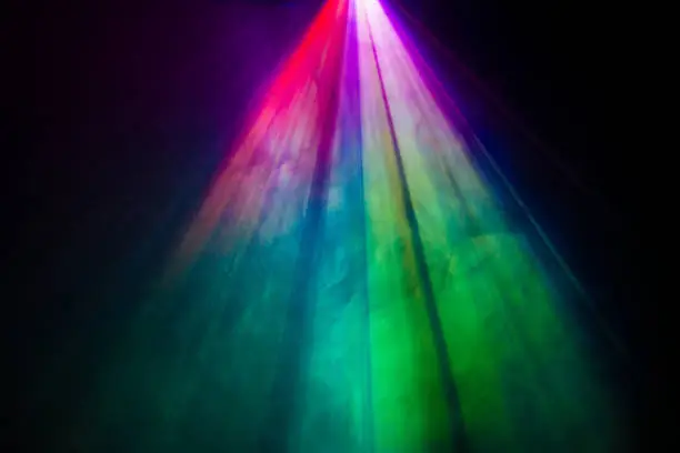 Photo of projector spotlight rainbow color on smoke texture .