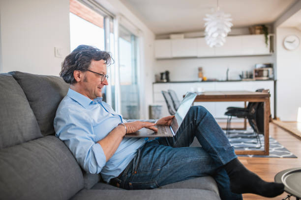 istock Single Mature Man Enjoying a Relaxed Break on the Couch With His Laptop 1146275045
