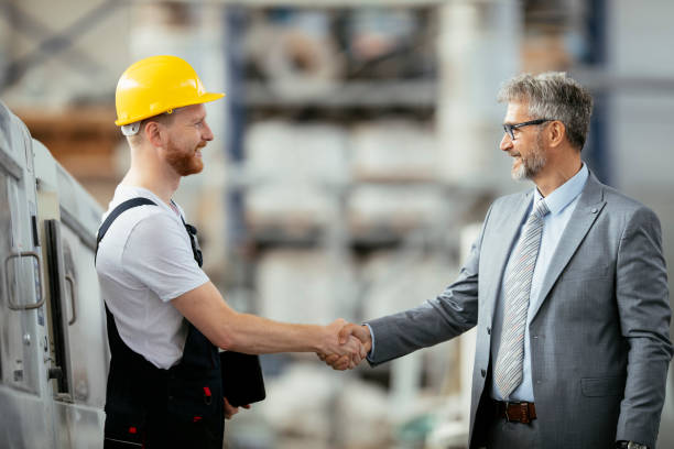 istock Factory. Worker. Manager. Engineer. Inspector. Factory worker handshaking with quality inspector. 1146276673