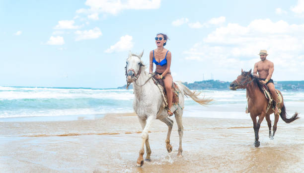 istock Young Couple riding a horse on the beach 1146279478
