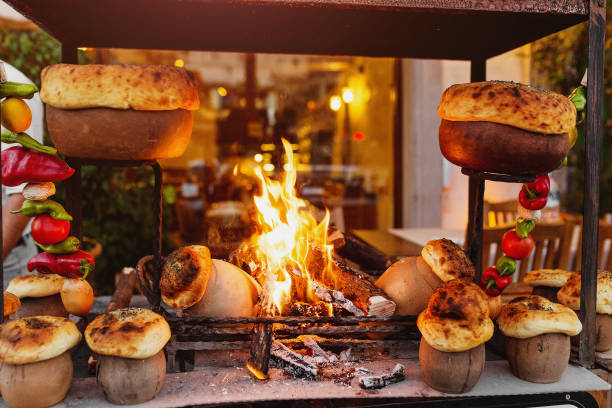 traditional Turkish Testi Kebab cooked in clay pot on open fire at night in restaurant, authentic oriental cuisine