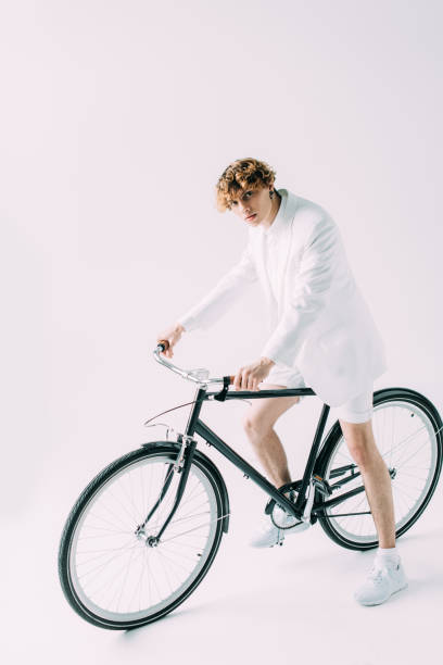 istock handsome man with curly hair riding bicycle on grey background 1146283614