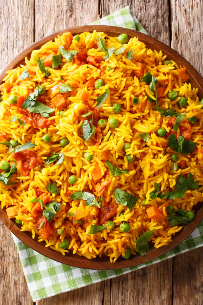 istock Vegetarian Indian rice with vegetables close-up on a plate. Vertical top view, rustic style 1146289066