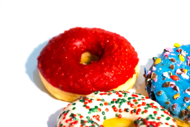 istock Sweet tasty donuts with colorful sprinkles isolated on white background 1146292181