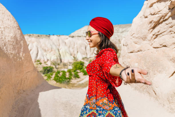 азиатская женщина-путешественница в ближневосточной пустыне в национальном платье с тюрбаном, следуйте за мной - women indigenous culture middle east traditional culture стоковые фото и изображения