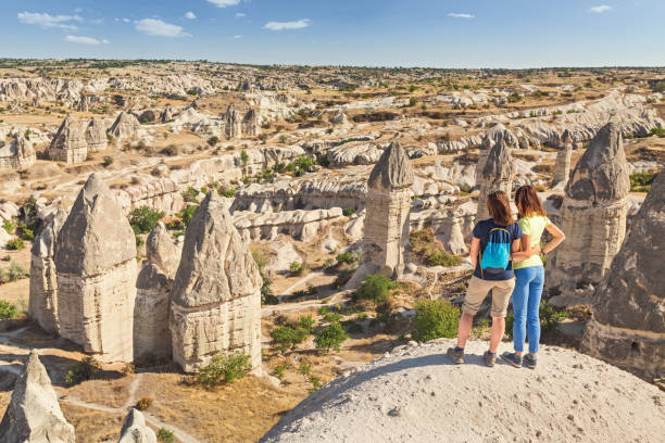 happy friends travelling and having fun in Goreme national park in Cappadocia fairy chimneys in Turkey happy friends travelling and having fun in Goreme national park in Cappadocia fairy chimneys in Turkey rose valley stock pictures, royalty-free photos & images