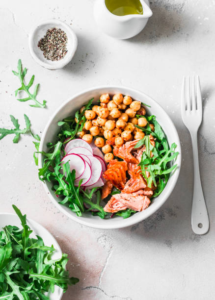 istock Spicy chickpeas, baked salmon, crispy radish, arugula salad on a light background, top view 1146295180
